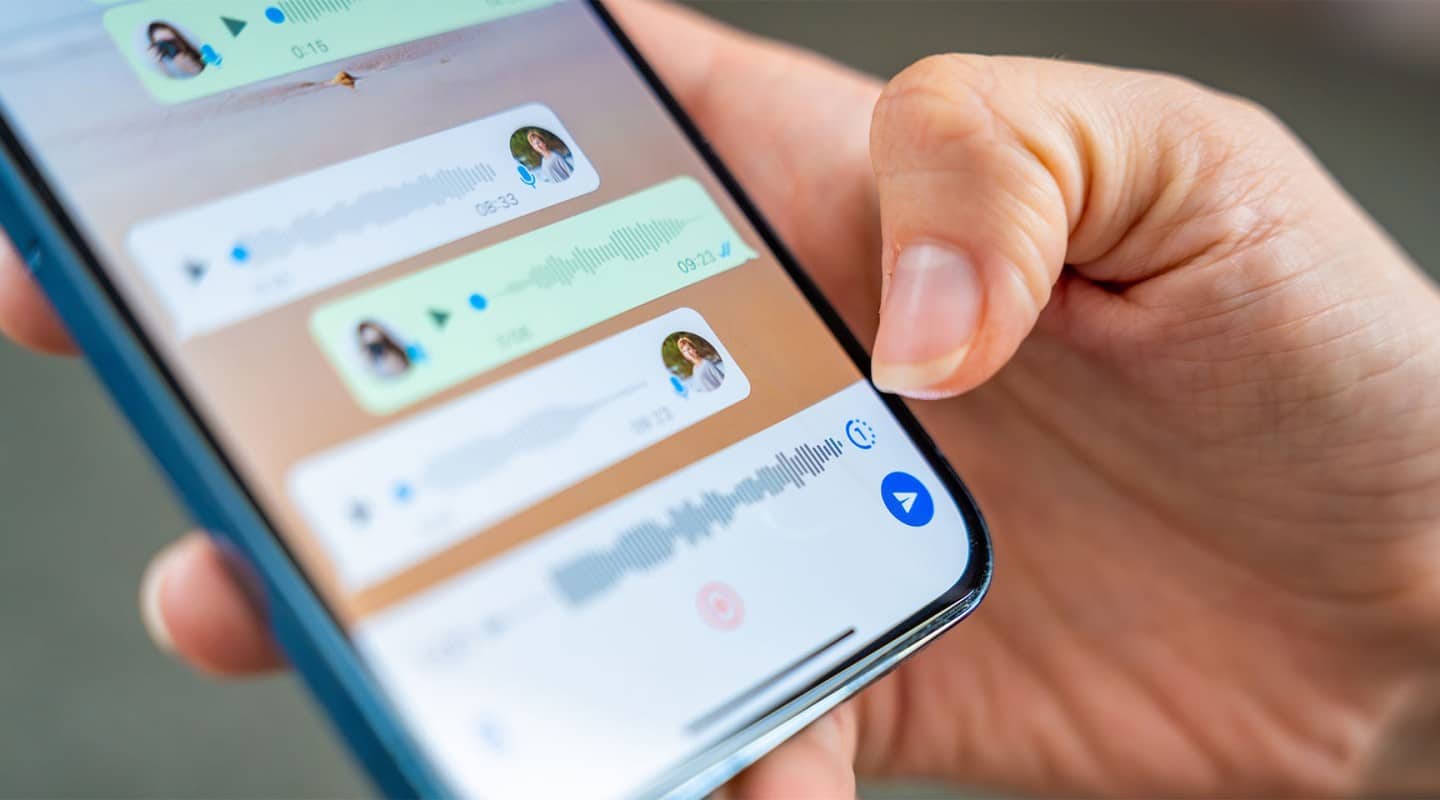 person holding a phone and in a group chat that may be a scam