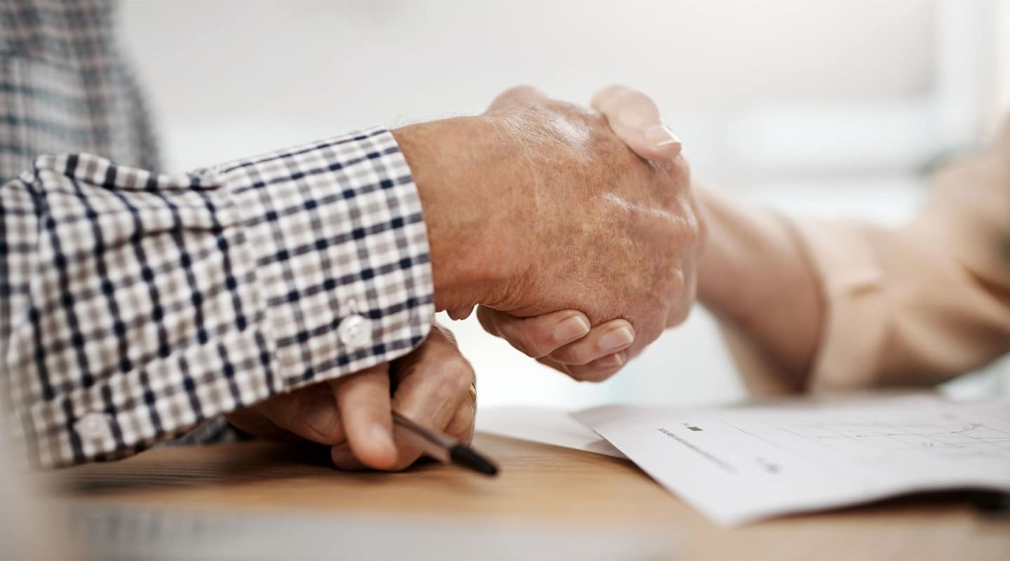 senior man shaking hand with financial advisor